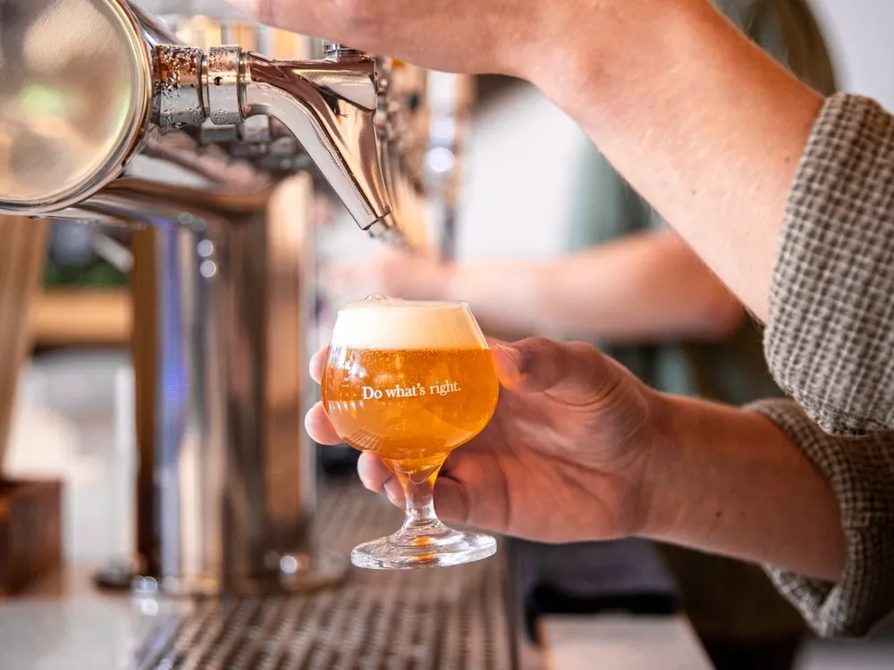 Person pouring beer from tap into glass with foam and text 'Do what's right.'
