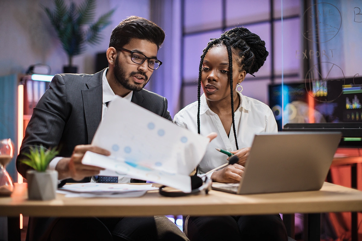 Two multicultural company workers discussing a budget