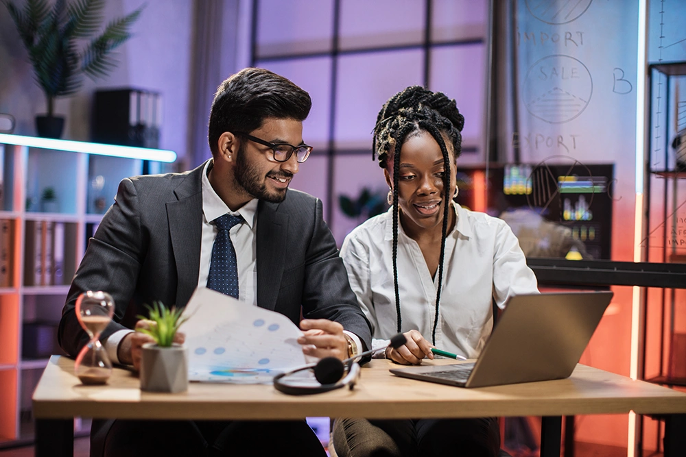 Two multicultural company workers discussing a budget
