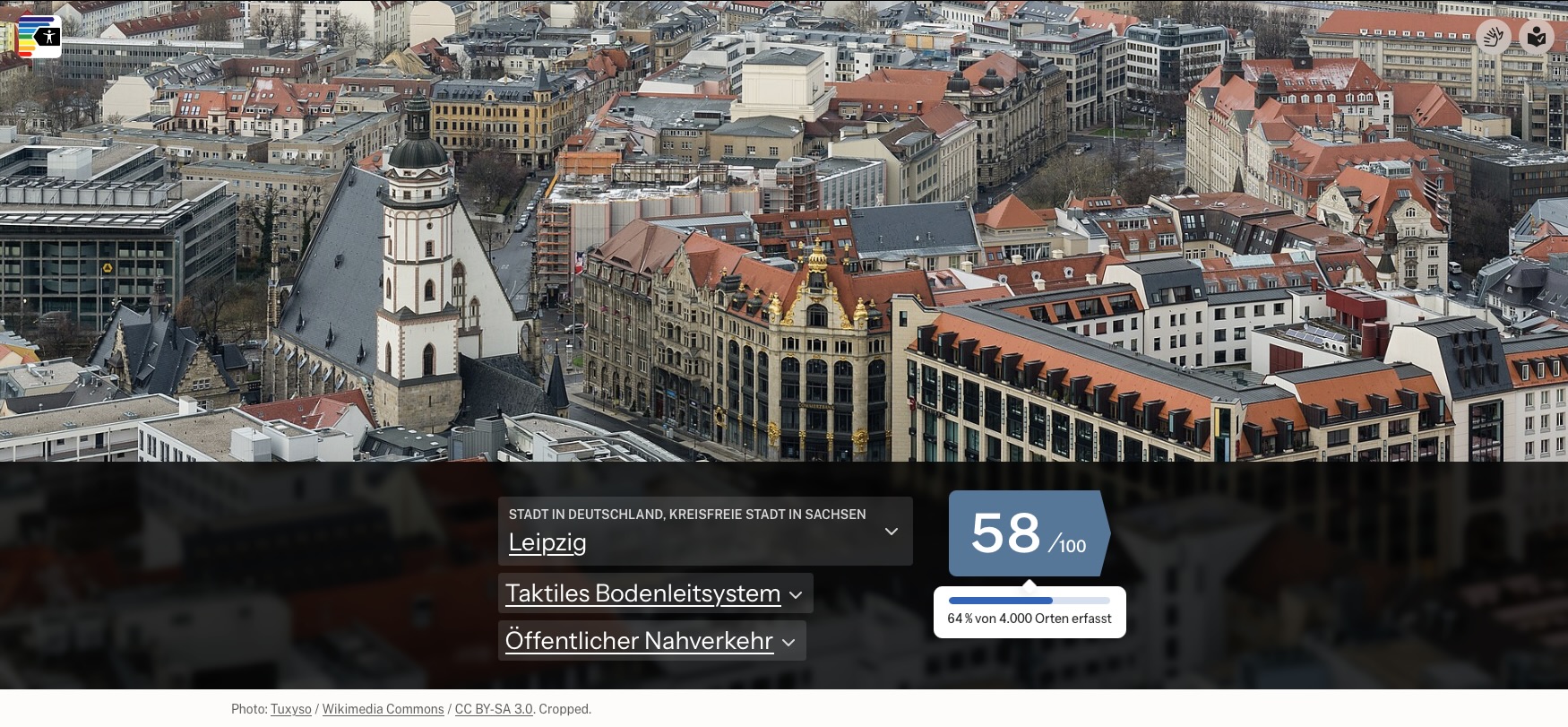 Screenshot der Website a11y-Score. Oben ein Luftbild der Leipziger Innenstadt mit der Thomaskirche und roten Ziegeldächern. Darunter die Auswahl: Leipzig, kreisfreie Stadt in Sachsen, Kriterium „Taktiles Bodenleitsystem“, Ortstyp „Öffentlicher Nahverkehr“. Daneben der Score 58 von 100 und die Info: 64 Prozent von rund 4.000 Orten erfasst. Ein Balkendiagramm zeigt, dass der Score aus 2.571 von 4.022 Orten berechnet wurde: 1.486 Orte mit Bodenleitsystem (blau), 1.085 Orte ohne (orange) und 1.451 Orte ohne Angabe (gestrichelt).