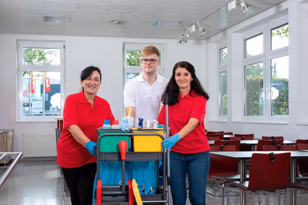 Drei Reinigungskräfte der integrativen Betriebe die nach der Arbeit stolz den sauberen Raum verlassen.