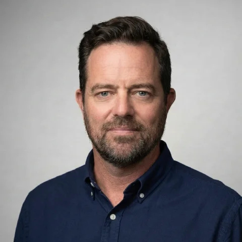 A man wearing glasses and a blue shirt.