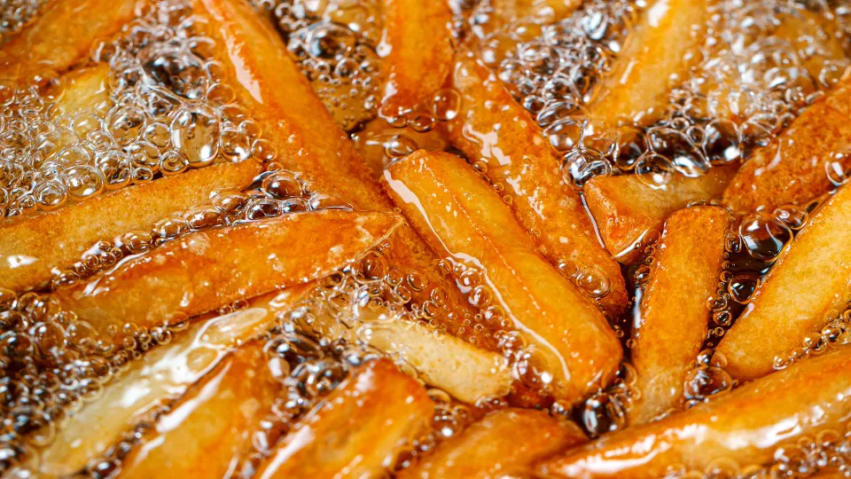 A man in a striped suit stands in front of a large digital display at Times Square with Nasdaq congratulating Pacaso on their new co-ownership listings. The scene is busy, with people walking and tall buildings in the background.