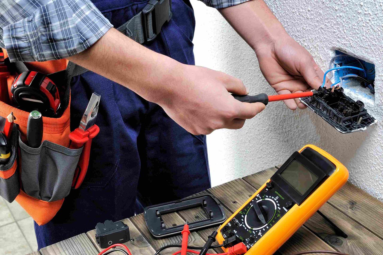 Nærbilde av elektriker som monterer stikkontakt med spesialverktøy og multimeter
