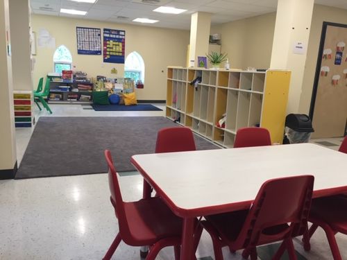 interior of youth education classroom with small tables, chairs, and toys