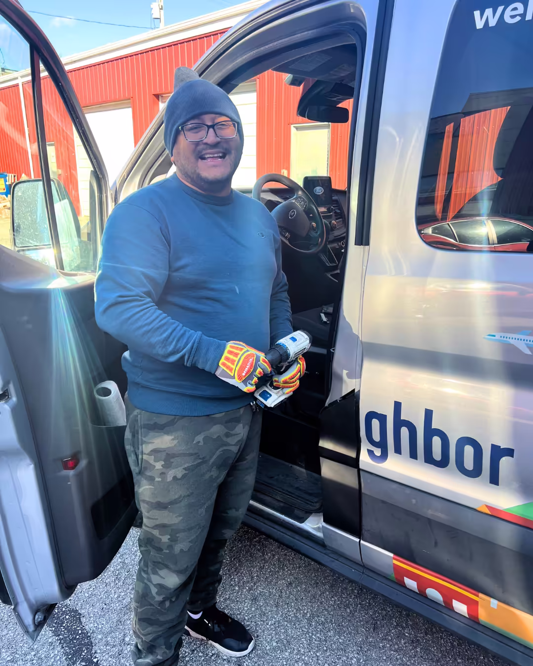 Driver smiling in door of Hello Neighbor van