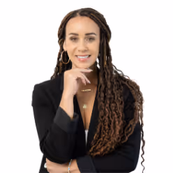 Confident woman with straight black hair, red lipstick, and crossed arms wearing a black cardigan and a heart-shaped necklace.