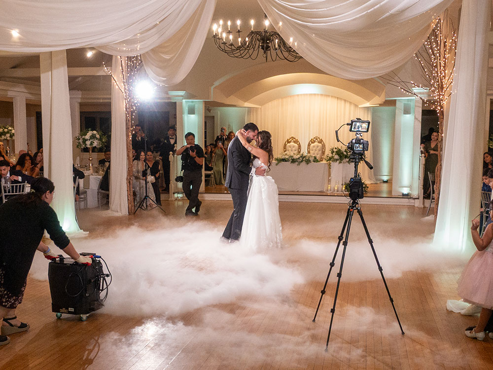 First dance on Dancing on Clouds — couple surrounded by low‑lying fog; Kenny Fiesta team managing effects for a cinematic moment.