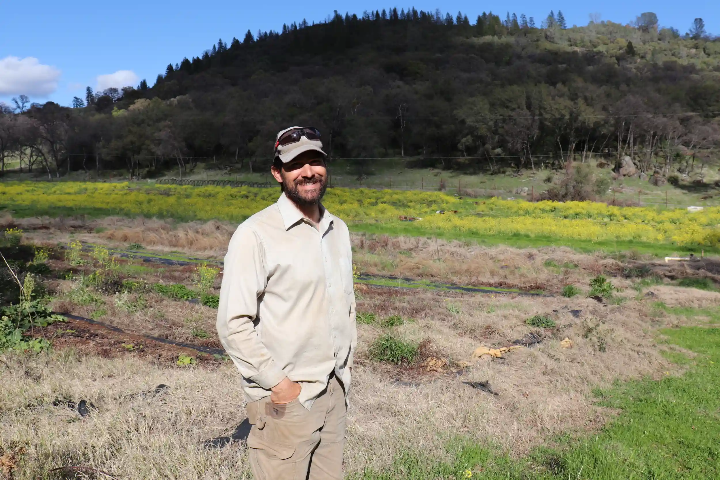 Antonio Garza, agricultor y participante en el programa Resilerator, sonríe frente a un campo.