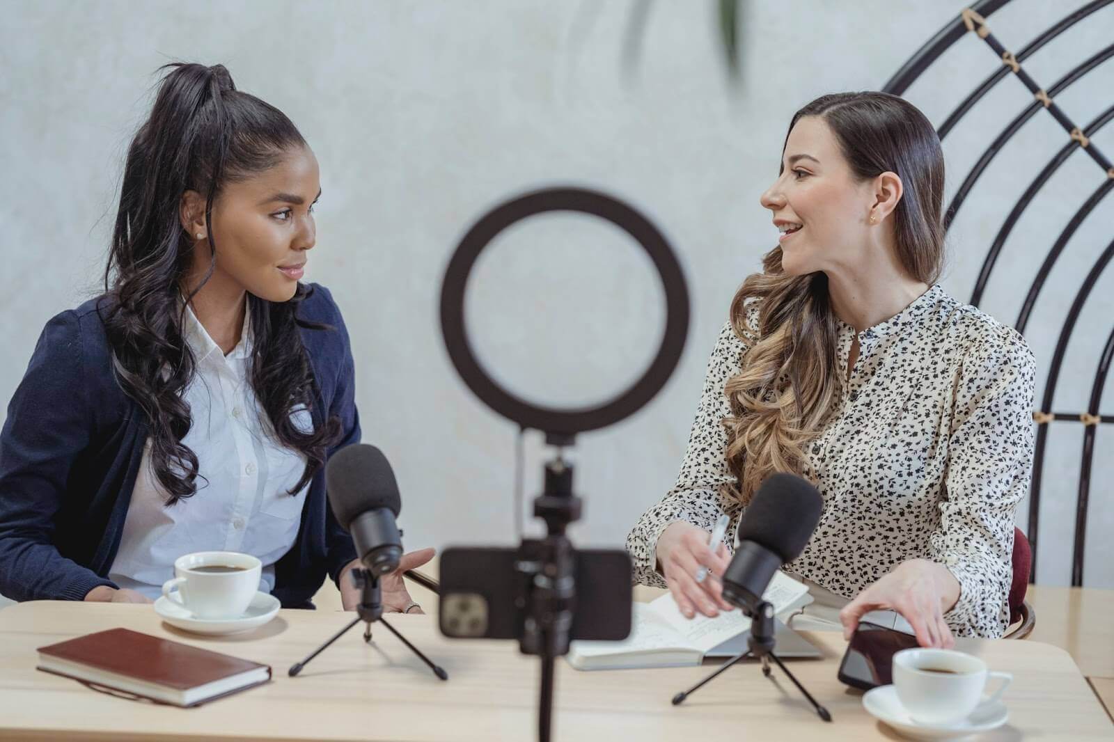 Smiling woman interviewing guest and recording video
