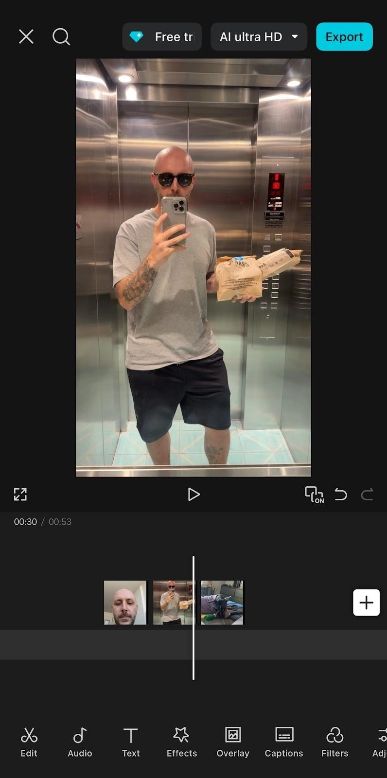 CapCut video editing timeline with a clip of a man taking a mirror selfie in an elevator.