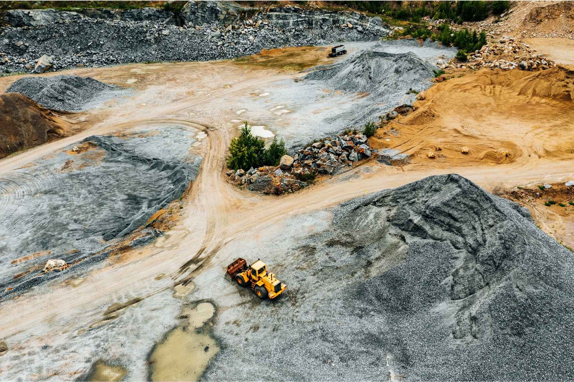Aerial view of an active quarry site. The scene underscores the duty to notify regulatory bodies and stakeholders about ongoing activities that may impact the environment and surrounding communities.