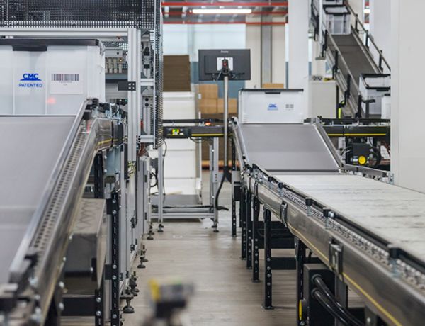 A factory with a conveyor belt and a person in the background.