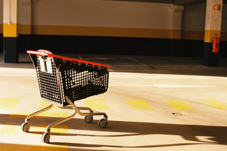 A shopping cart is sitting in a parking lot.