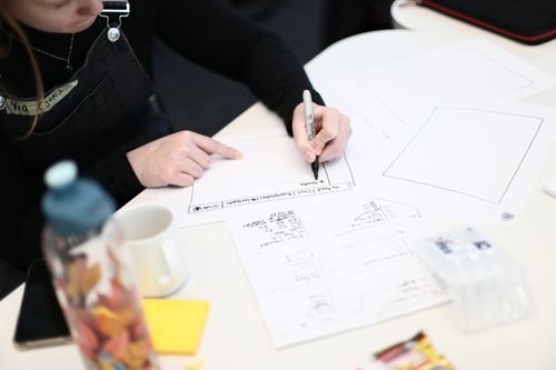 A girl sketching user interfaces on paper