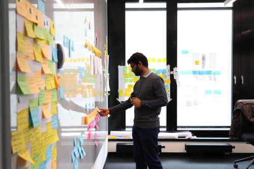 A man sorting stickies on a whiteboard