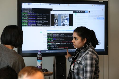 Engineers discussing code snippets in front of a screen
