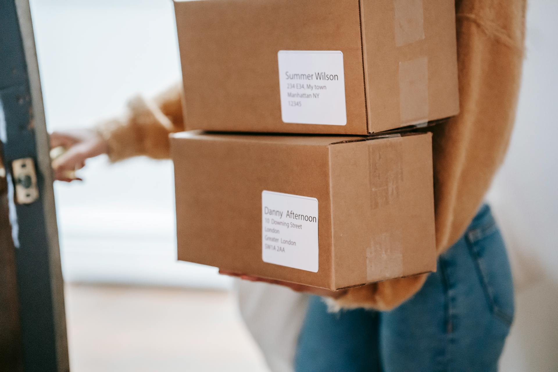 A person holding two boxes with the name Danny Afternoon on them.
