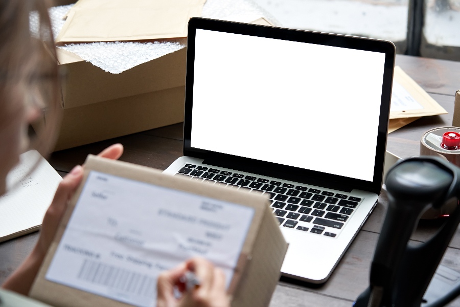 A laptop with a white screen sitting on a wooden table.
