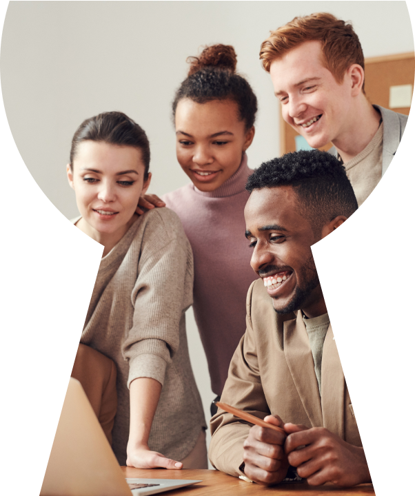 A group of people smiling and laughing in front of a computer.