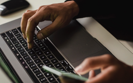 A person is typing on a laptop computer.
