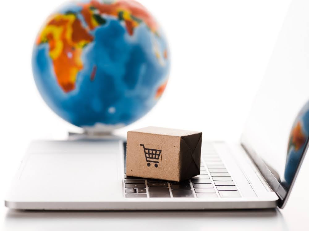 A laptop with a box on it and a globe in the background.