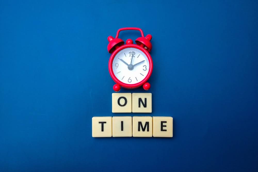 A red alarm clock with the word time on it.