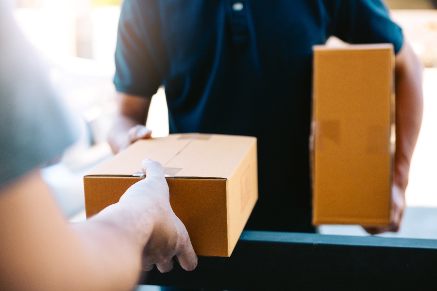 A person is holding a brown box.