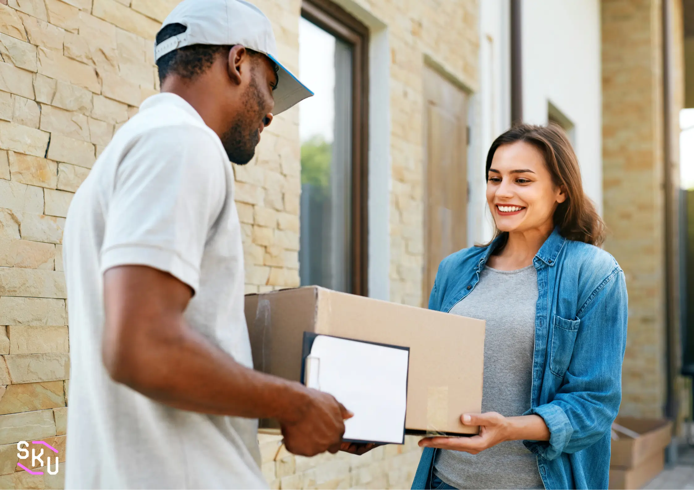 A man in a grey shirt is holding a box.