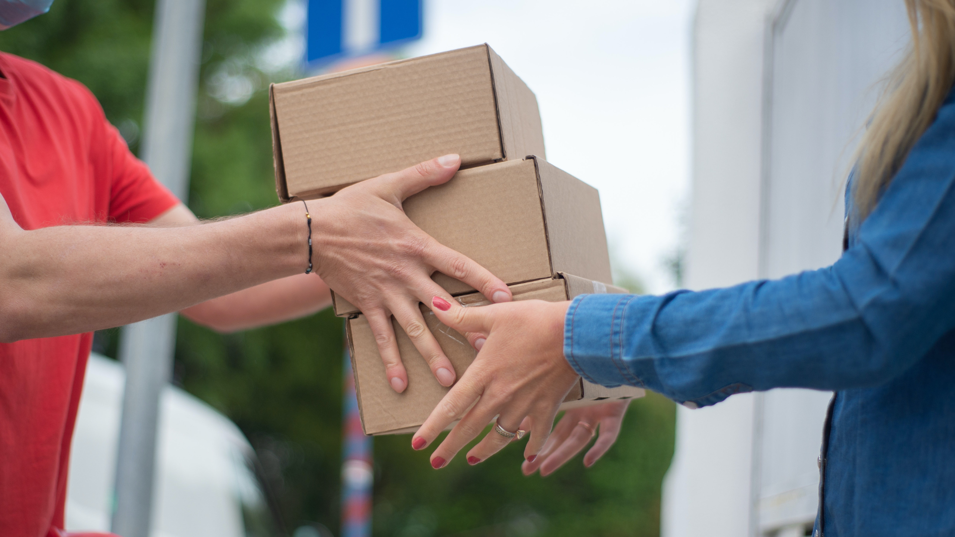 Two people holding a box of items.