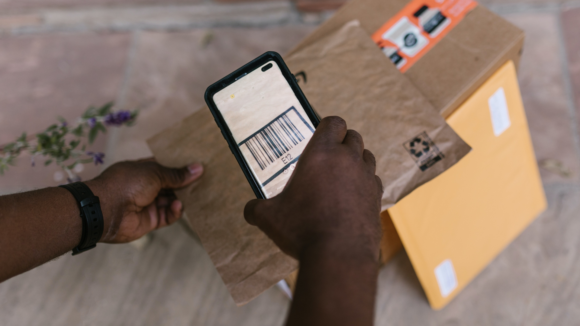 A person holding a cell phone with a barcode on the screen.