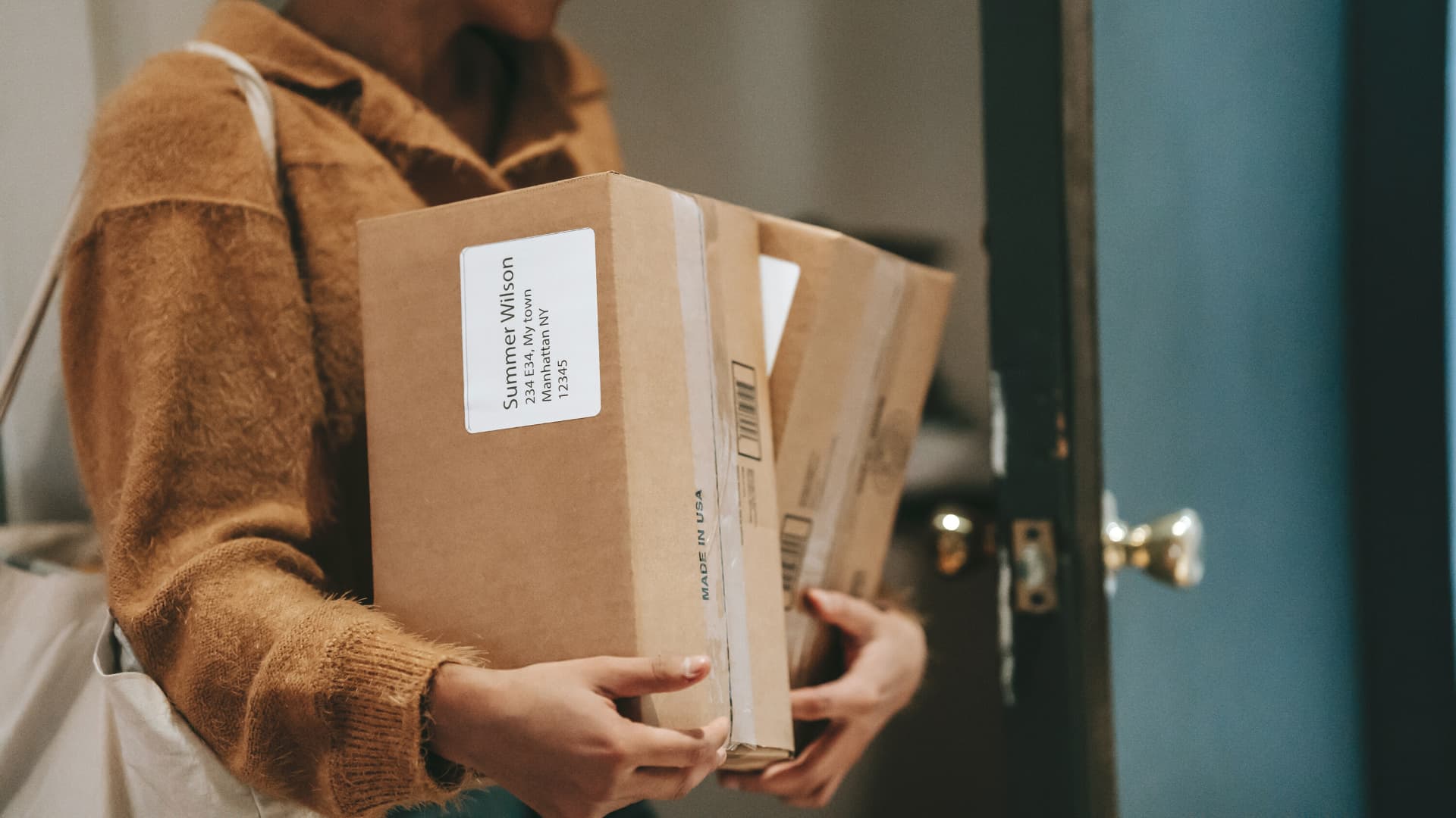 A person holding a box with a label on it.
