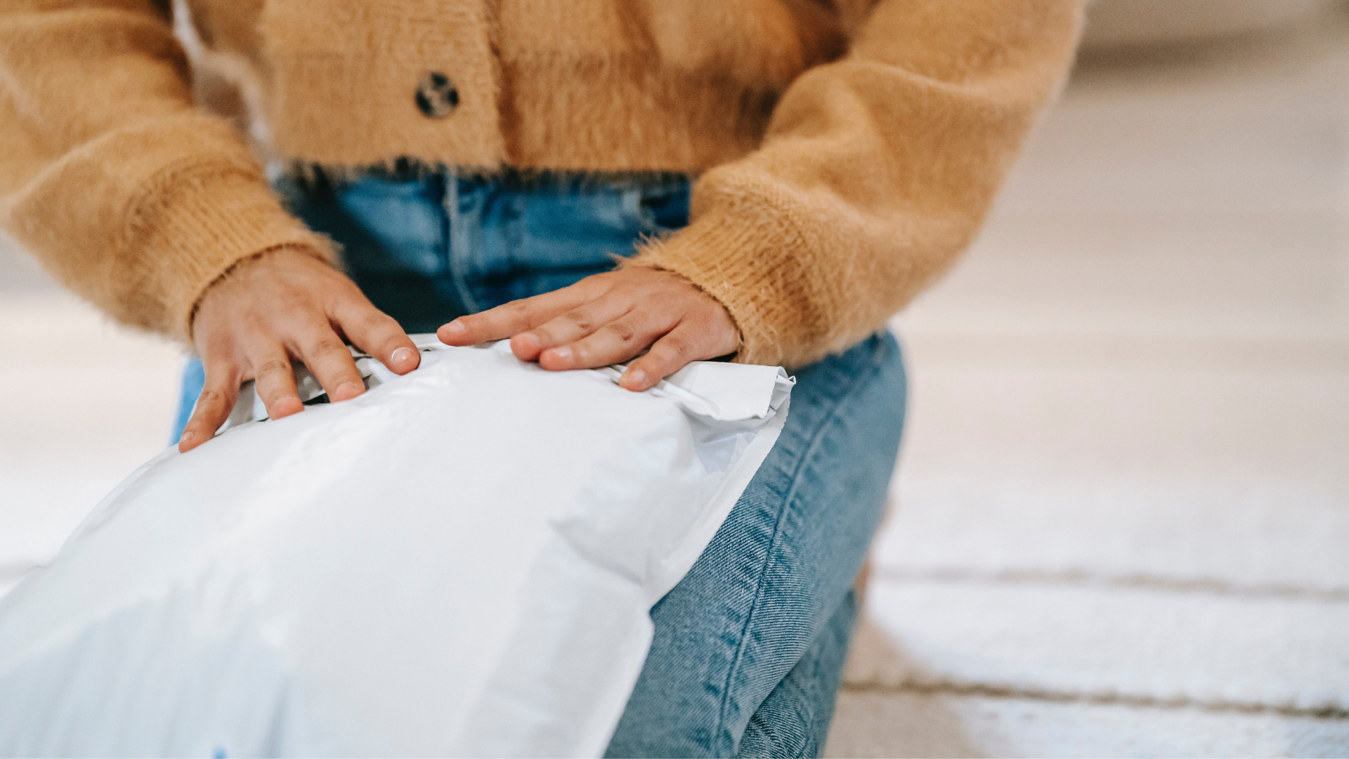 A person sitting on the floor with a package in their lap.
