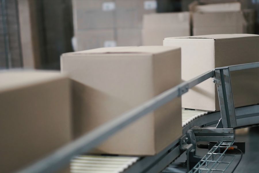 Packages moving along a conveyor belt symbolising streamlined ecommerce supply chains.