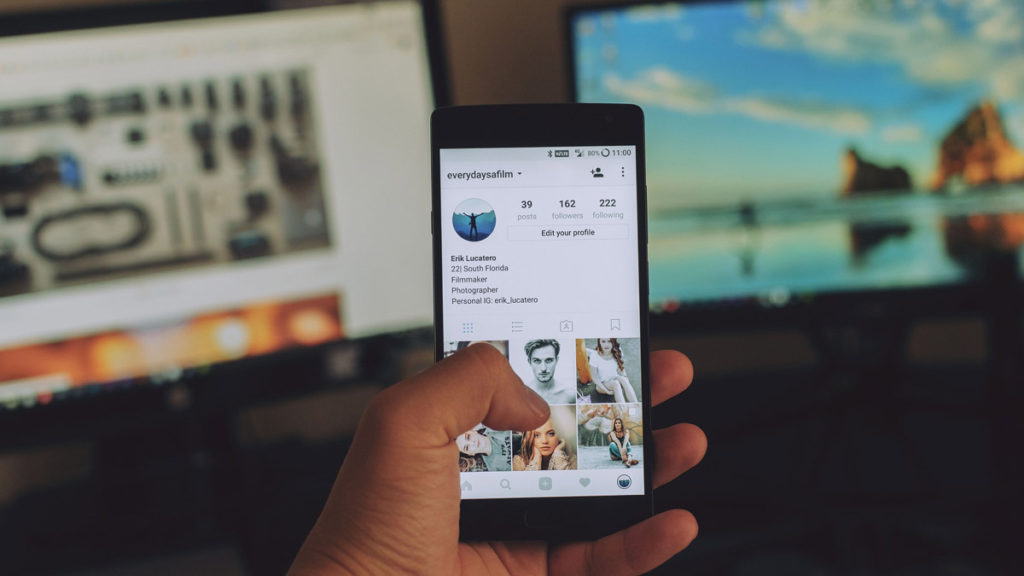 A person holding a cell phone with a picture of a man on it.