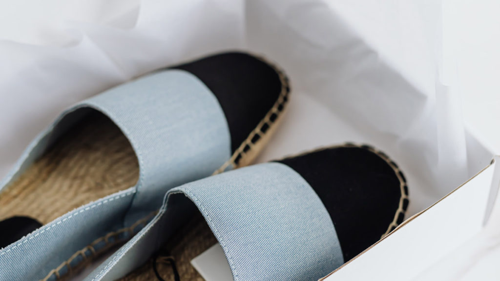 A pair of blue and black shoes in a white box.