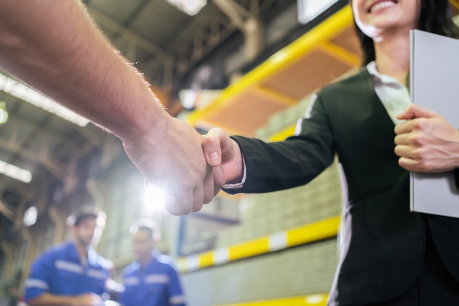 Business partners shaking hands in a warehouse when choosing a 3PL provider