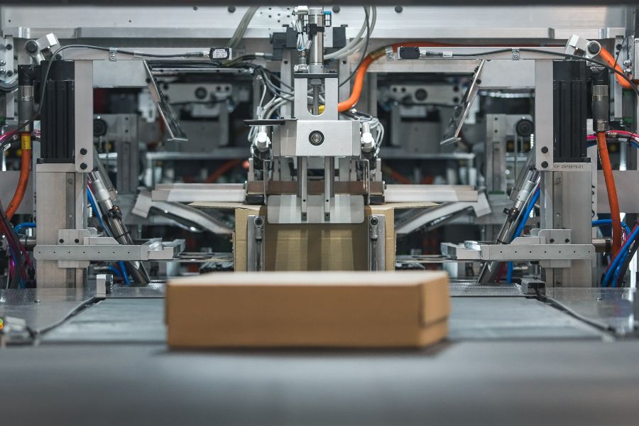 Automated robots and a robotic arm moving boxed goods inside a modern warehouse