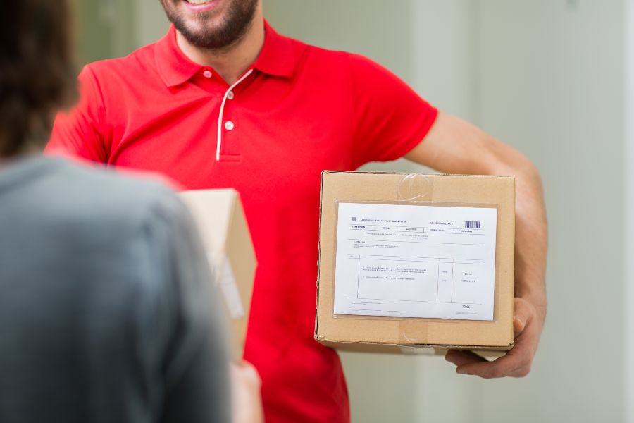 Courier handing a parcel to a customer, representing strong service and customer loyalty