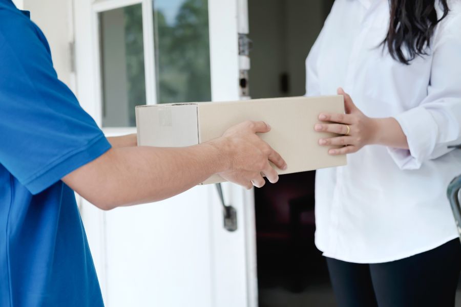 A man in a blue shirt is holding a box.