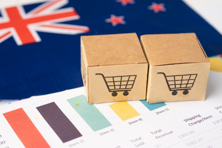 Two small shipping boxes with cart icons on trade charts and an Australian flag in the background.