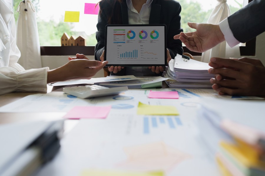 Business professionals review charts and graphs on tablet for 3PL performance management.