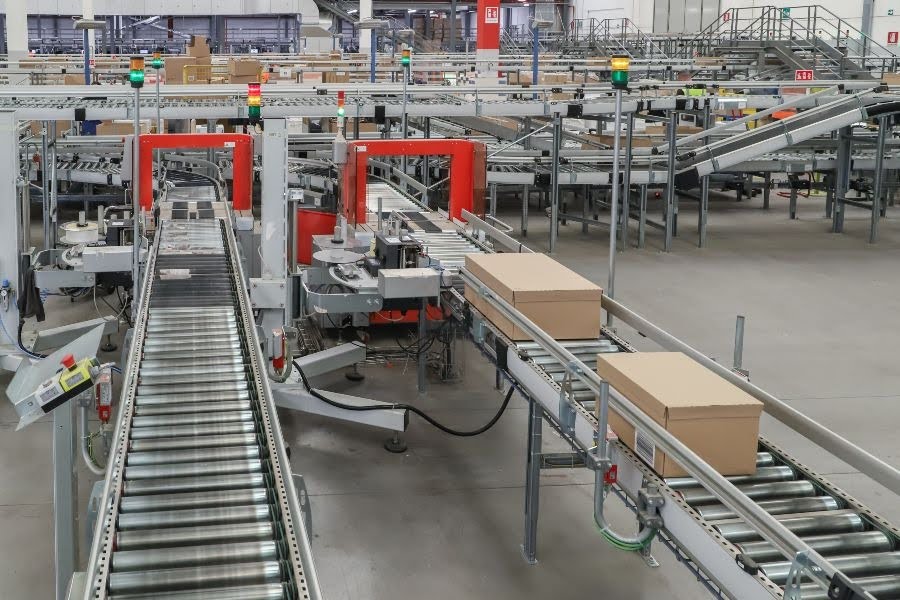 Automated warehouse conveyor line moves boxes through a logistics facility.