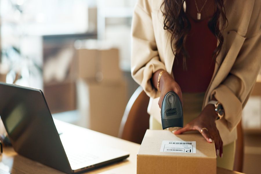 Woman scanning package label with barcode reader during order fulfilment process