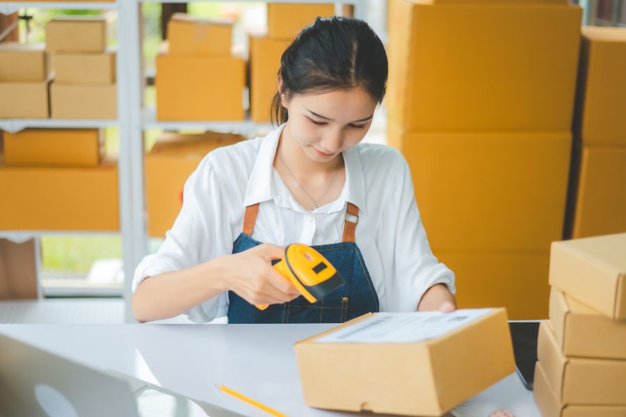 Fulfilment centre worker scanning packages with RF scanner to improve picking accuracy