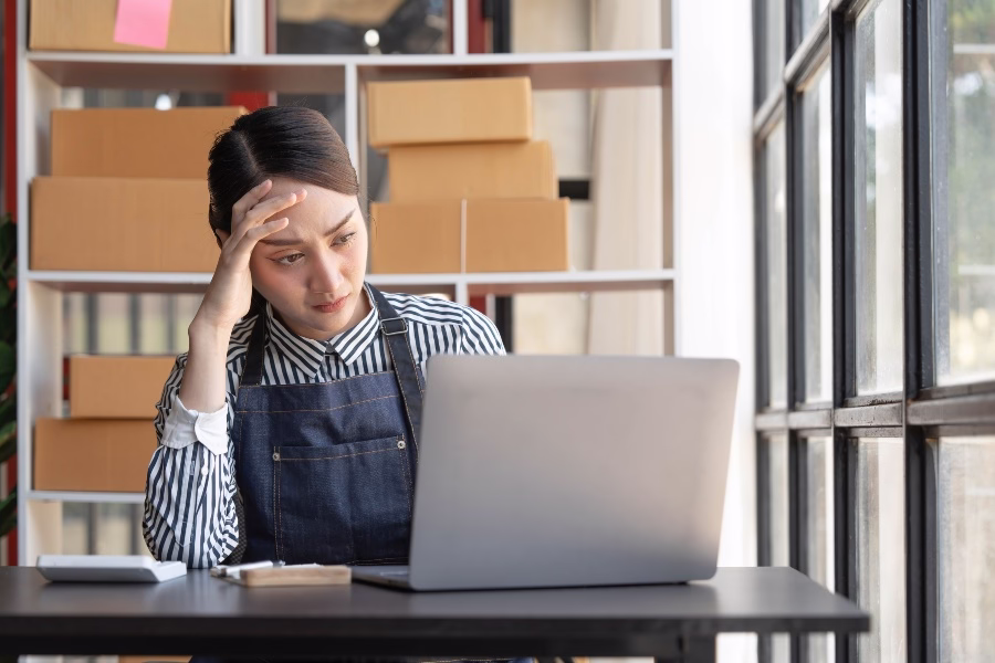 Stressed business owner working beside boxes
