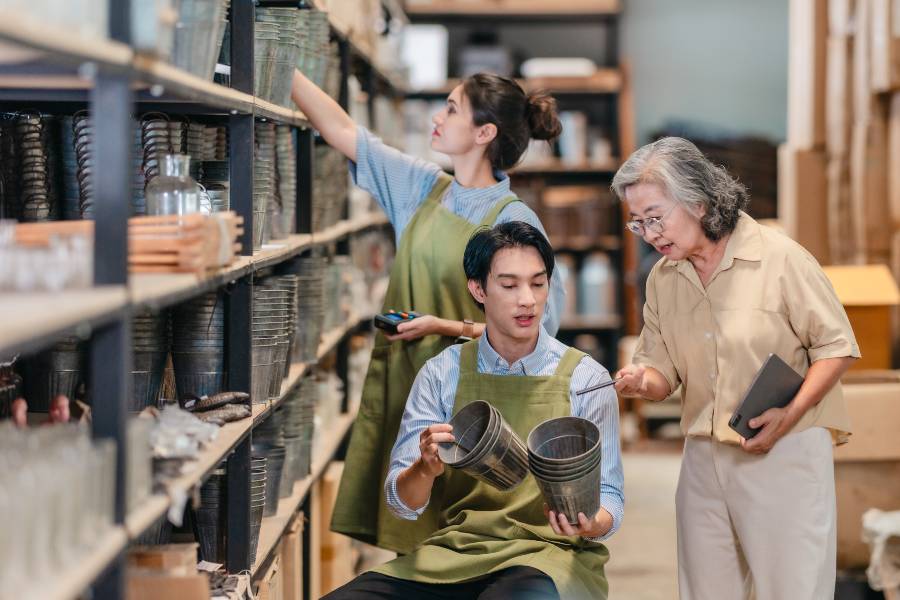 Small business staff checking and organising shelved inventory to maintain safety stock levels