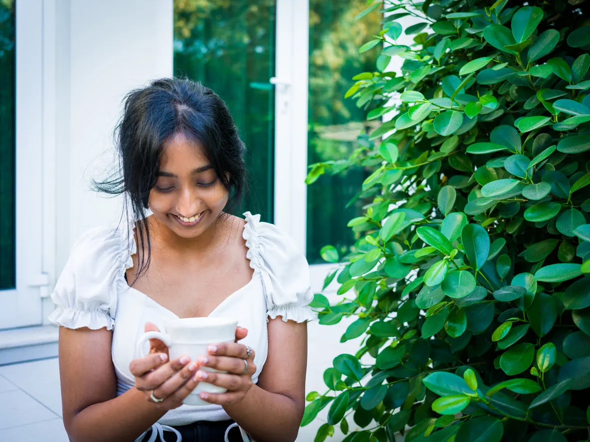 shy girl holding coffee while talking