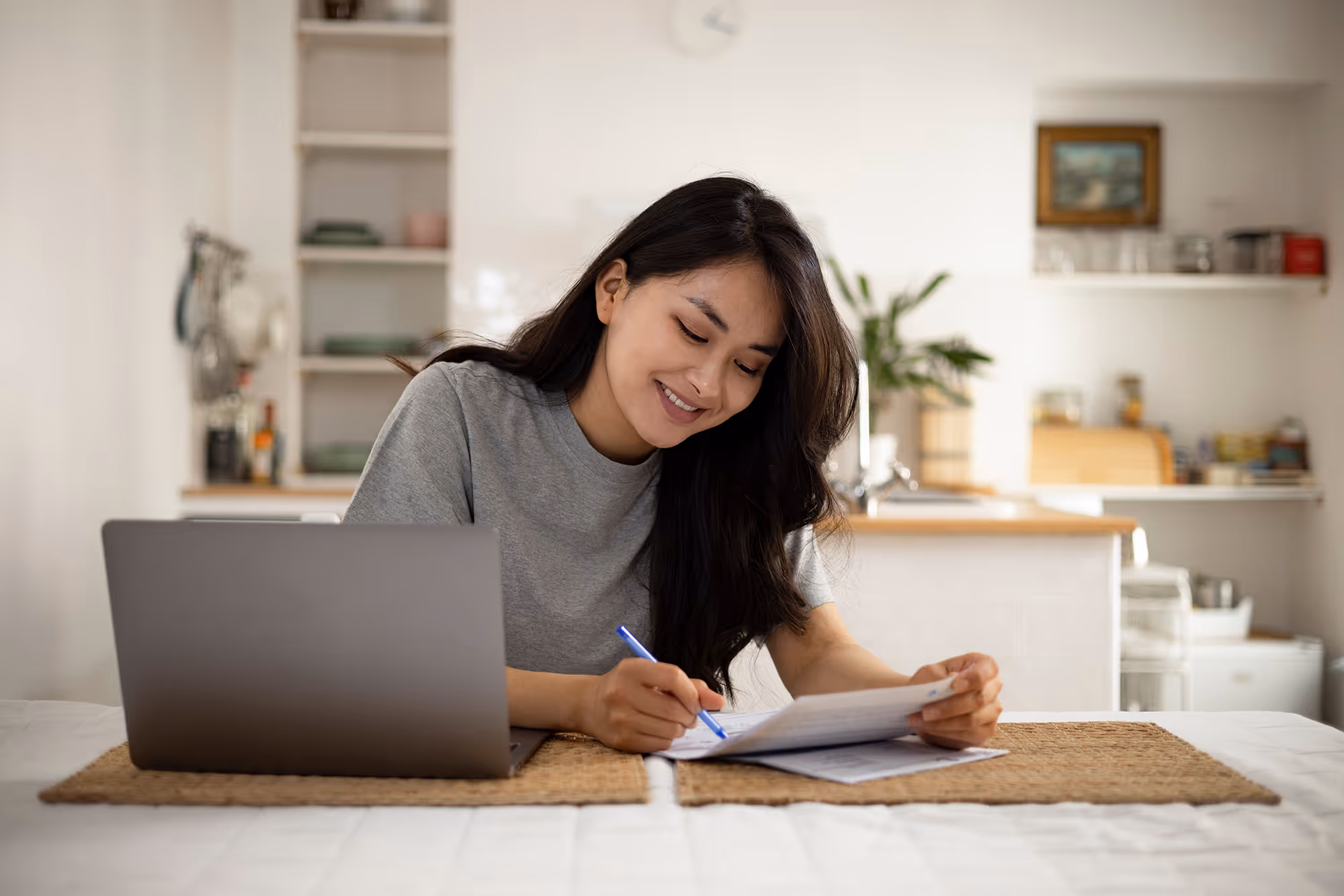 Blog post thumbnail: Email Signature Audit for Mortgage Companies - Woman reviewing checklist next to laptop