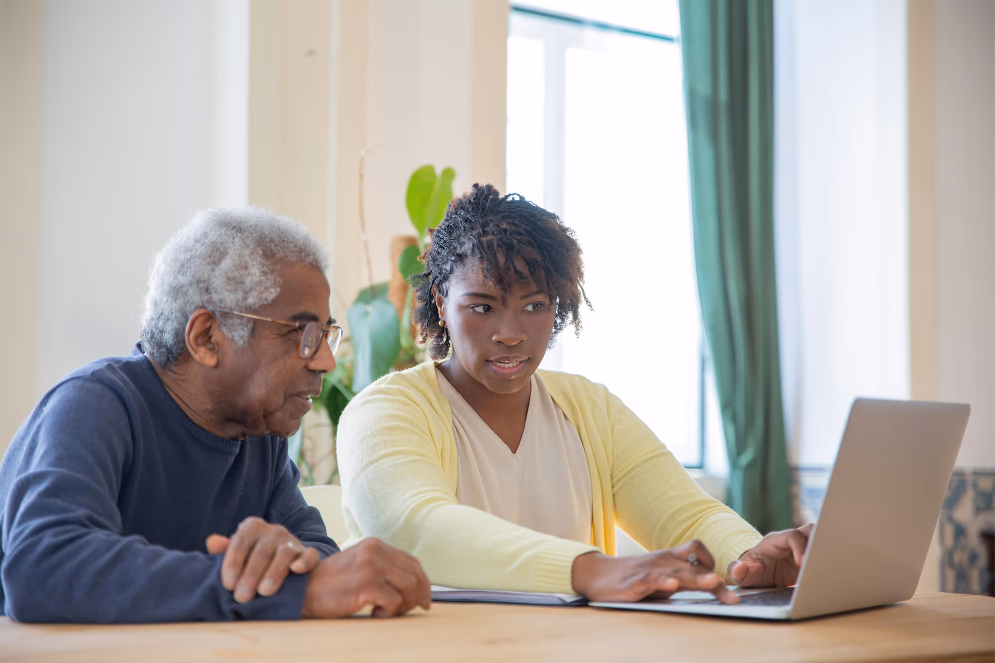 Senior living playbook cover image - Woman helping elderly man with computer, representing digital support for senior care